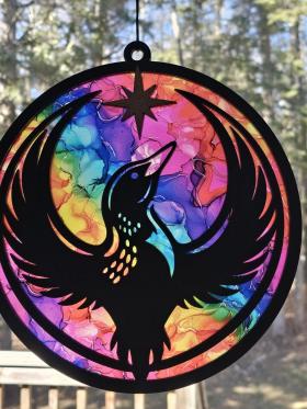Minnesota Rainbow Resistance Loon, Minnesota artist, suncatcher, translucent, northern lights. Made by Betsy Skagen of Blue Waters Studio & Emporium. Made in Minnesota.